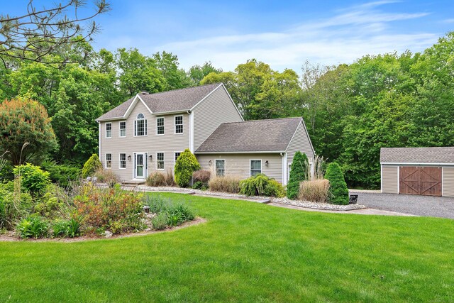 273 New London Rd, Colchester, CT 06415 - colonial house featuring an outbuilding, a front lawn, a detached garage, and roof with shingles