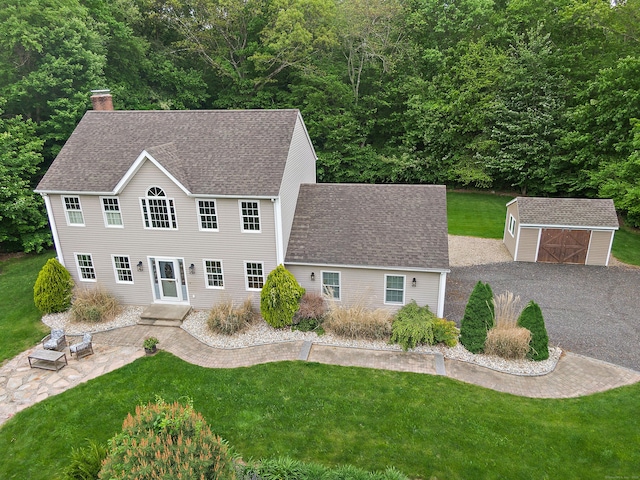 273 New London Rd, Colchester, CT 06415 - view of front facade with a front lawn, a chimney, a shingled roof, a patio area, and a garage