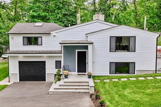23 Wyndover Ln N, Stamford, CT 06902 - view of front of property featuring a standing seam roof, metal roof, driveway, a front yard, and a garage