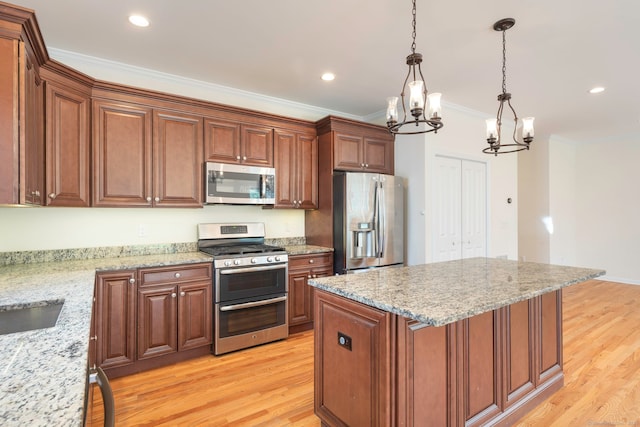 51 Lexington Gdns Unit 51, North Haven, CT 06473 - kitchen featuring stainless steel appliances, a chandelier, light wood finished floors, crown molding, and decorative light fixtures