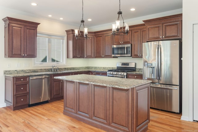 51 Lexington Gdns Unit 51, North Haven, CT 06473 - kitchen with stainless steel appliances, a sink, a center island, light wood-style flooring, and hanging light fixtures