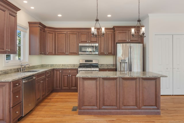 51 Lexington Gdns Unit 51, North Haven, CT 06473 - kitchen featuring appliances with stainless steel finishes, a chandelier, light wood-type flooring, crown molding, and a kitchen island