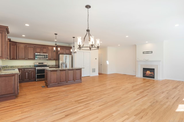 51 Lexington Gdns Unit 51, North Haven, CT 06473 - kitchen with stainless steel appliances, open floor plan, a center island, a chandelier, and a sink