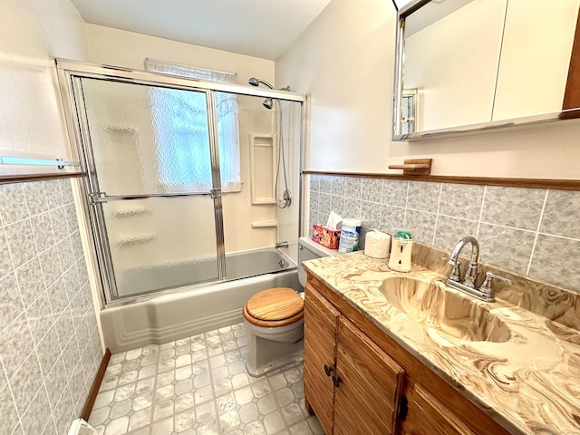 107 Montemerlo Ave, Windsor Locks, CT 06096 - full bathroom with tile walls, vanity, toilet, combined bath / shower with glass door, and a wainscoted wall