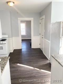 67 Ash St, Bridgeport, CT 06605 - kitchen with white range with gas cooktop, dark wood-type flooring, wainscoting, and light stone counters