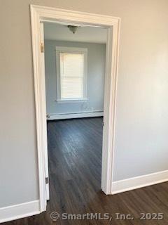 67 Ash St, Bridgeport, CT 06605 - corridor featuring dark wood-style floors and a baseboard heating unit