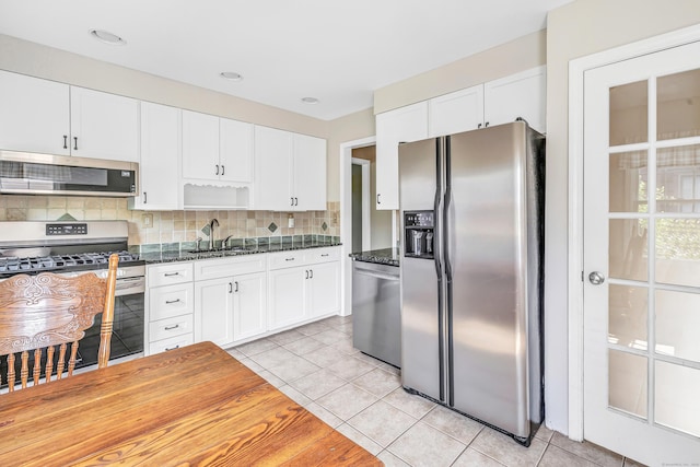 855 Stratford Rd, Stratford, CT 06615 - kitchen with stainless steel appliances, light tile patterned floors, white cabinets, decorative backsplash, and open shelves