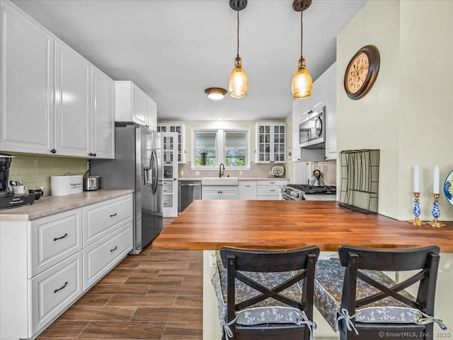 102 Columbus Ave, Meriden, CT 06451 - kitchen with a sink, appliances with stainless steel finishes, tasteful backsplash, white cabinets, and glass insert cabinets