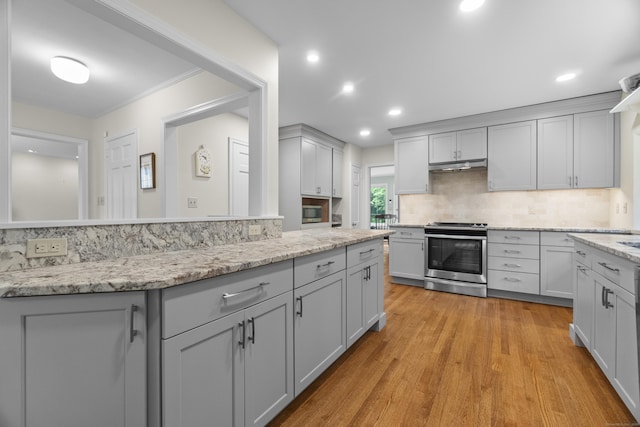 89 Pease Rd, Woodbridge, CT 06525 - kitchen with stainless steel stove, under cabinet range hood, gray cabinetry, light wood finished floors, and recessed lighting