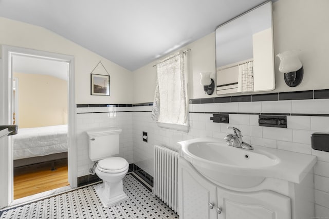 89 Pease Rd, Woodbridge, CT 06525 - full bath with radiator heating unit, tile walls, vanity, toilet, and lofted ceiling
