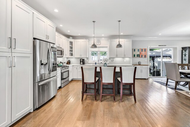 74 Sterling St, Fairfield, CT 06825 - kitchen featuring appliances with stainless steel finishes, healthy amount of natural light, a kitchen island, light wood-style flooring, and recessed lighting