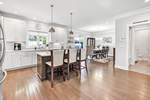 74 Sterling St, Fairfield, CT 06825 - kitchen featuring a kitchen island, healthy amount of natural light, light countertops, a breakfast bar, and recessed lighting