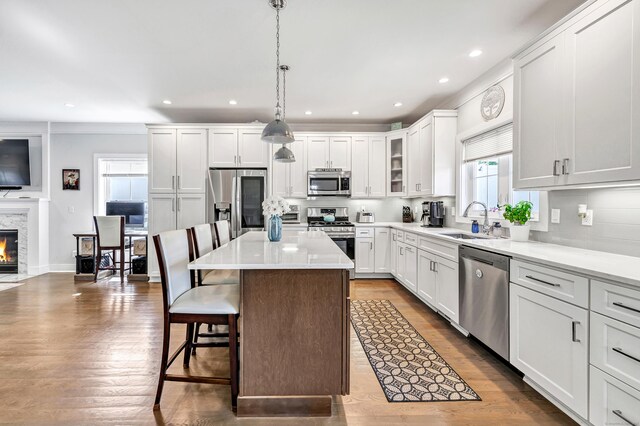 74 Sterling St, Fairfield, CT 06825 - kitchen with stainless steel appliances, a breakfast bar, recessed lighting, a kitchen island, and a sink