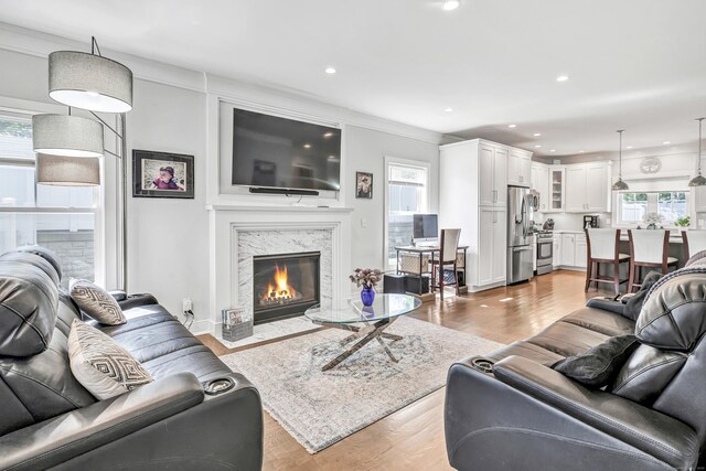 74 Sterling St, Fairfield, CT 06825 - living room featuring healthy amount of natural light, light wood-type flooring, recessed lighting, a high end fireplace, and crown molding