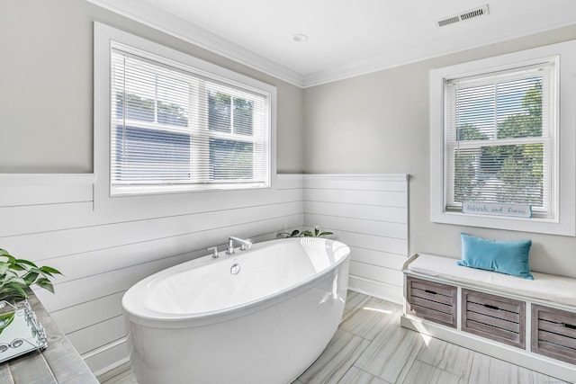 74 Sterling St, Fairfield, CT 06825 - bathroom featuring a soaking tub, ornamental molding, and a wainscoted wall