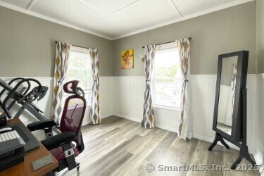 25 Myrtle Ave, Ansonia, CT 06401 - exercise room featuring wood finished floors, healthy amount of natural light, wainscoting, and ornamental molding