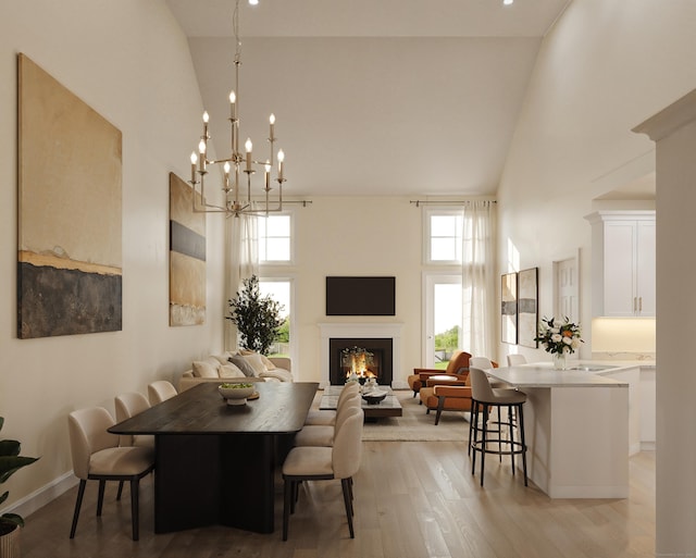 N Benson Rd Unit 47, Middlebury, CT 06762 - dining area featuring high vaulted ceiling, healthy amount of natural light, light wood-style flooring, a warm lit fireplace, and a chandelier