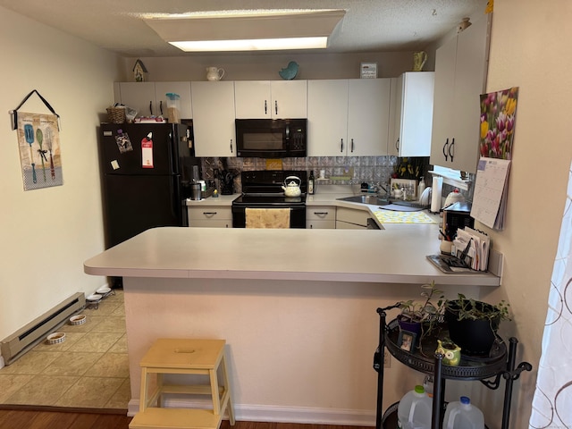 925 Oronoke Rd Unit 26F, Waterbury, CT 06708 - kitchen featuring black appliances, a baseboard radiator, a peninsula, and light countertops