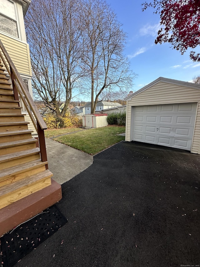 18 New St, Ansonia, CT 06401 - view of grassy yard with stairway, an outdoor structure, a detached garage, and driveway