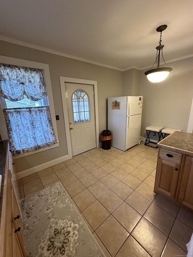 18 New St, Ansonia, CT 06401 - kitchen with freestanding refrigerator, crown molding, light tile patterned floors, hanging light fixtures, and baseboards