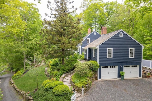 286 Limestone Rd, Ridgefield, CT 06877 - view of home's exterior featuring a chimney, a garage, and driveway