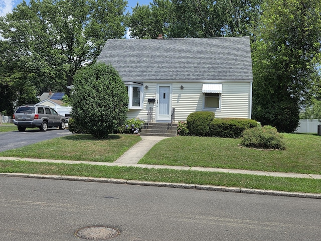 13 Harkness Dr, Milford, CT 06460 - cape cod-style house featuring a front yard, a shingled roof, and asphalt driveway