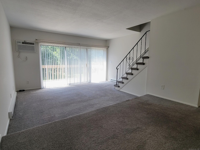 213 Baxter Rd Apt D, Mansfield, CT 06268 - unfurnished living room with carpet floors, stairs, a wall unit AC, baseboards, and a textured ceiling