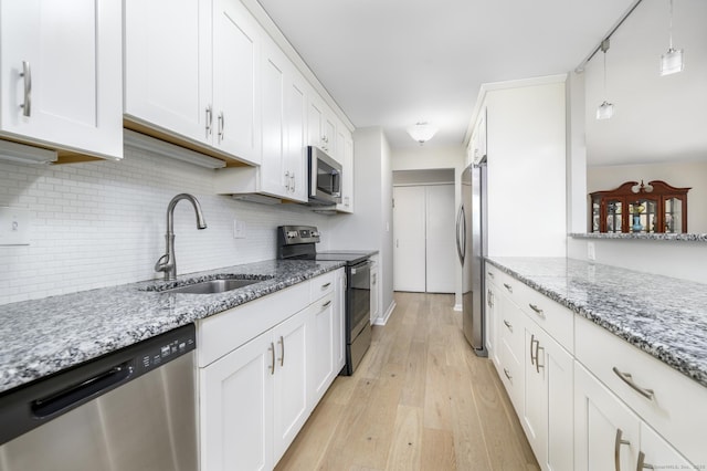 1 Strawberry Hill Ave Apt 7A, Stamford, CT 06902 - kitchen featuring appliances with stainless steel finishes, backsplash, light wood-style floors, white cabinets, and light stone counters