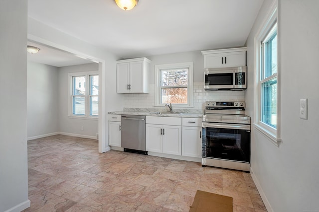 82 Sunnyside Ave, Waterbury, CT 06708 - kitchen with stainless steel appliances, plenty of natural light, tasteful backsplash, and baseboards