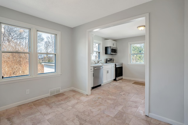 82 Sunnyside Ave, Waterbury, CT 06708 - kitchen with appliances with stainless steel finishes, white cabinetry, baseboards, and light countertops