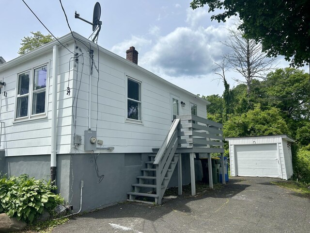 82 Sunnyside Ave, Waterbury, CT 06708 - rear view of house featuring an outbuilding, a chimney, stairway, driveway, and a garage