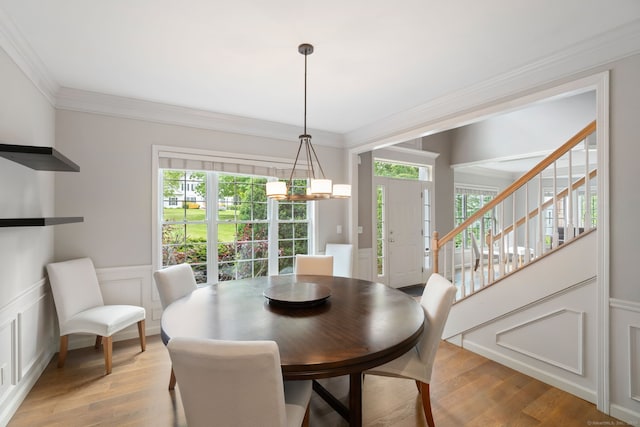 41 Leeward Ln, Groton, CT 06340 - dining area with healthy amount of natural light, light wood finished floors, a decorative wall, crown molding, and a wainscoted wall