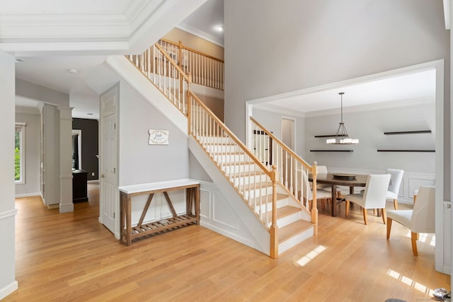 41 Leeward Ln, Groton, CT 06340 - stairs with wood finished floors, ornamental molding, ornate columns, a chandelier, and a towering ceiling