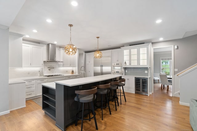 41 Leeward Ln, Groton, CT 06340 - kitchen featuring wall chimney range hood, appliances with stainless steel finishes, wine cooler, decorative backsplash, and light countertops