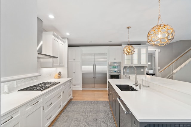 41 Leeward Ln, Groton, CT 06340 - kitchen featuring a sink, stainless steel appliances, wall chimney exhaust hood, white cabinetry, and tasteful backsplash