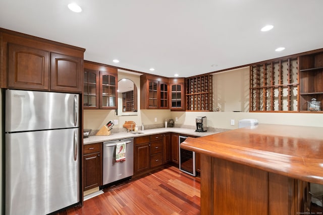 41 Leeward Ln, Groton, CT 06340 - kitchen with appliances with stainless steel finishes, beverage cooler, light countertops, light wood-style floors, and glass insert cabinets