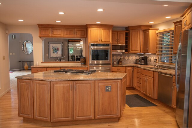 43 Metacomet Rd, Farmington, CT 06032 - kitchen featuring stainless steel appliances, a sink, a center island, light wood-type flooring, and tasteful backsplash