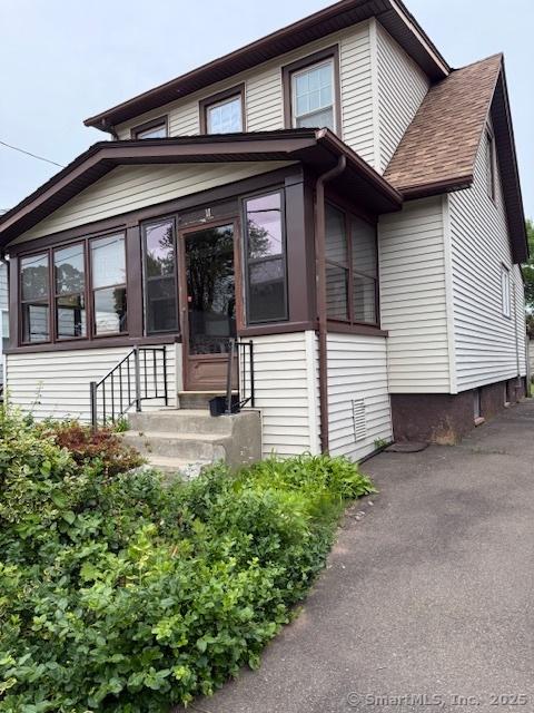 11 Deerfield St, East Haven, CT 06512 - view of front of home featuring entry steps, a sunroom, and roof with shingles