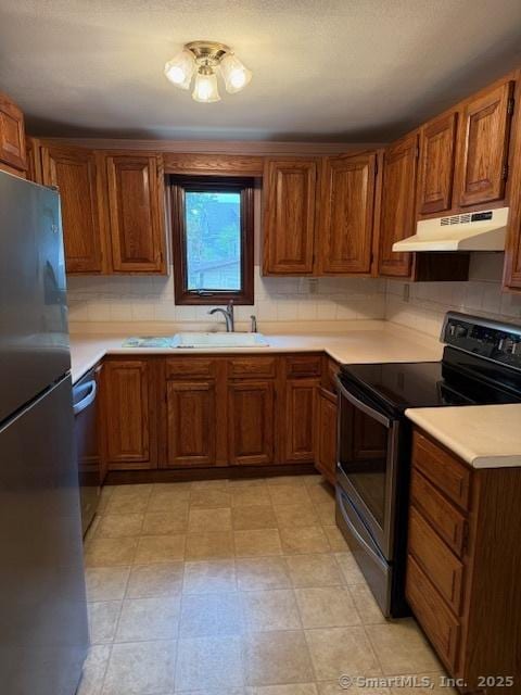 11 Deerfield St, East Haven, CT 06512 - kitchen with stainless steel appliances, under cabinet range hood, light countertops, and brown cabinets