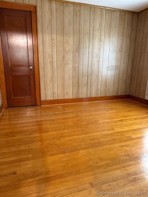 11 Deerfield St, East Haven, CT 06512 - spare room featuring light wood-type flooring and wood walls