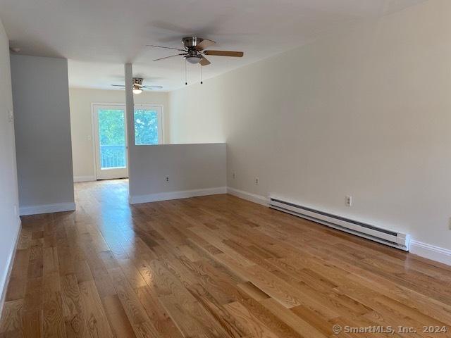 57 Senior Dr Unit 57, Monroe, CT 06468 - spare room featuring a baseboard heating unit, ceiling fan, wood finished floors, and baseboards