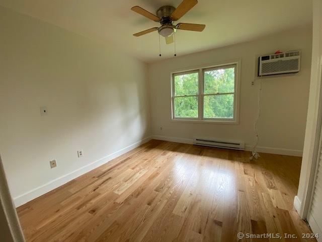 57 Senior Dr Unit 57, Monroe, CT 06468 - empty room with baseboard heating, light wood-style flooring, and baseboards