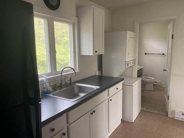 44 Josies Ring Rd, Monroe, CT 06468 - kitchen with freestanding refrigerator, stacked washing machine and dryer, light tile patterned floors, and white cabinetry