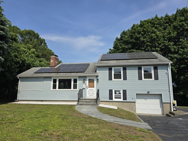 206 Bridgeview Pl, Stratford, CT 06614 - split level home with entry steps, an attached garage, a front lawn, and a chimney