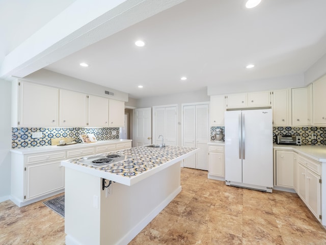 27 Powderhorn Dr, Ridgefield, CT 06877 - kitchen featuring freestanding refrigerator, a sink, tasteful backsplash, light countertops, and white cabinetry