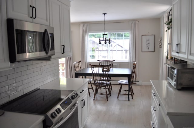 12 Derby Ct Unit 12, Brookfield, CT 06804 - kitchen featuring appliances with stainless steel finishes, decorative backsplash, a chandelier, light wood-style floors, and white cabinets