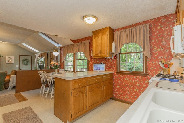 37 Sage Dr, Berlin, CT 06037 - kitchen with wallpapered walls, a peninsula, light countertops, brown cabinets, and lofted ceiling