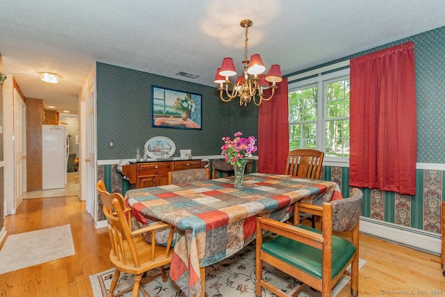 37 Sage Dr, Berlin, CT 06037 - dining area featuring wallpapered walls, a chandelier, light wood-type flooring, a baseboard radiator, and a textured ceiling