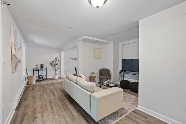 34 Pleasant St Unit 6, Plainfield, CT 06374 - living room with wood finished floors, baseboard heating, a textured ceiling, and baseboards