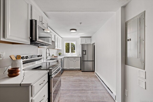 34 Pleasant St Unit 6, Plainfield, CT 06374 - kitchen with stainless steel appliances, baseboard heating, electric panel, light wood-style floors, and a sink